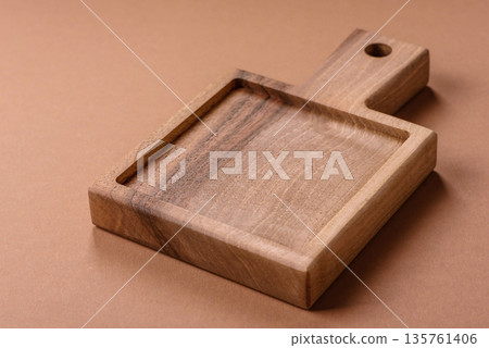 Wood, a wooden empty cutting board on a dark kitchen table. Wooden cutting board Wood, a wooden empty cutting board on a dark kitchen table. Wooden cutting board 135761406