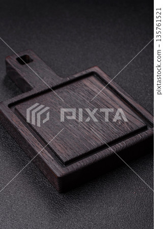 Wood, a wooden empty cutting board on a dark kitchen table. Wooden cutting board Wood, a wooden empty cutting board on a dark kitchen table. Wooden cutting board 135761521