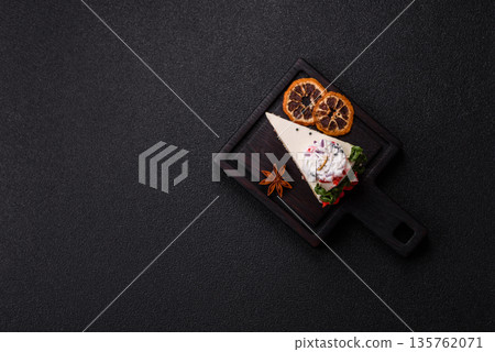 A slice of sweet layered cake with a Christmas ornament and fruit flavor. A slice of cake 135762071