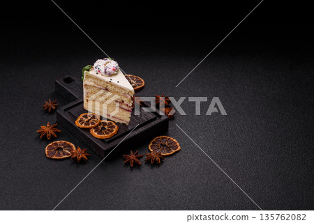 A slice of sweet layered cake with a Christmas ornament and fruit flavor. A slice of cake 135762082