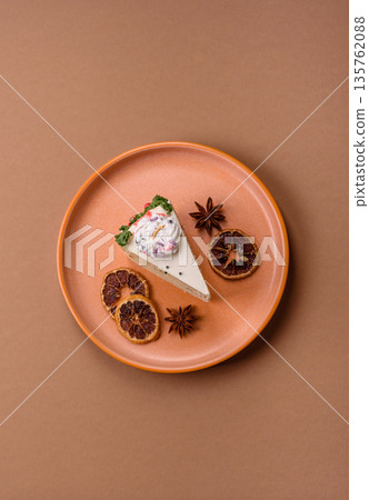 A slice of sweet layered cake with a Christmas ornament and fruit flavor. A slice of cake A slice of sweet layered cake with a Christmas ornament and fruit flavor. A slice of cake 135762088