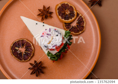 A slice of sweet layered cake with a Christmas ornament and fruit flavor. A slice of cake A slice of sweet layered cake with a Christmas ornament and fruit flavor. A slice of cake 135762094