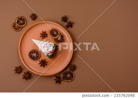 A slice of sweet layered cake with a Christmas ornament and fruit flavor. A slice of cake 135762098