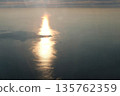 從飛機舷窗俯瞰，夕陽西下，大海和島嶼在陽光下閃閃發光。 135762359