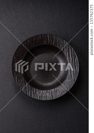 An empty round ceramic plate on a table, kitchenware. An empty plate An empty round ceramic plate on a table, kitchenware. An empty plate 135762375