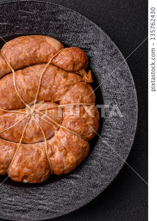 Grilled sausage in the shape of a spiral or snail, from chicken or pork. Spiral or snail sausage Grilled sausage in the shape of a spiral or snail, from chicken or pork. Spiral or snail sausage 135762430