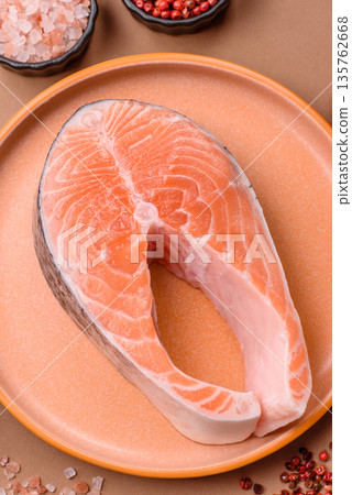 Fish, raw salmon steak, fresh seafood for grilling with salt, spices, and herbs. Raw salmon steak Fish, raw salmon steak, fresh seafood for grilling with salt, spices, and herbs. Raw salmon steak 135762668