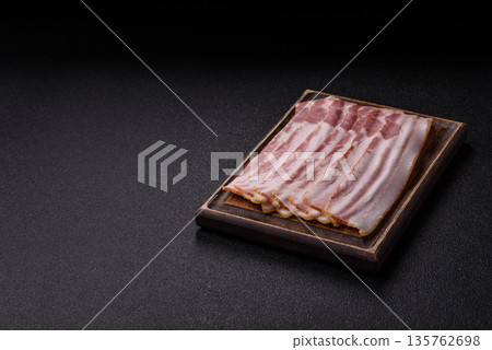 Raw smoked bacon slices, ham, jamon, or prosciutto strips for cooking. Raw bacon slices Raw smoked bacon slices, ham, jamon, or prosciutto strips for cooking. Raw bacon slices 135762698