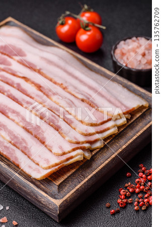 Raw smoked bacon slices, ham, jamon, or prosciutto strips for cooking. Raw bacon slices 135762709