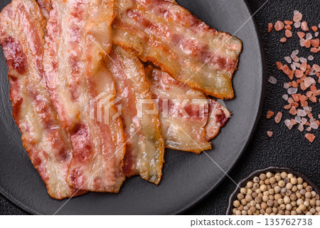 Fried smoked bacon slices, ham, jamon, or prosciutto strips for cooking. Fried bacon Fried smoked bacon slices, ham, jamon, or prosciutto strips for cooking. Fried bacon 135762738