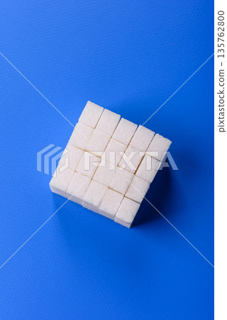 Sweet white sugar cubes as a source of glucose. White sugar cubes as a food background 135762800