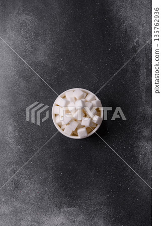 Sweet white sugar cubes as a source of glucose. White sugar cubes as a food background 135762936