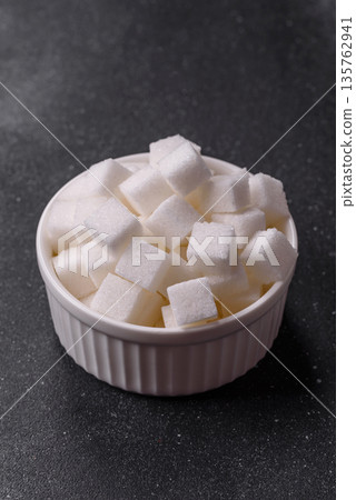 Sweet white sugar cubes as a source of glucose. White sugar cubes as a food background Sweet white sugar cubes as a source of glucose. White sugar cubes as a food background 135762941