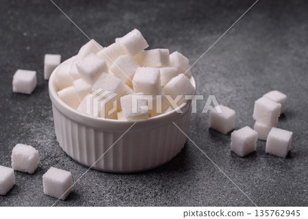 Sweet white sugar cubes as a source of glucose. White sugar cubes as a food background 135762945