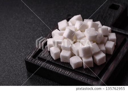 Sweet white sugar cubes as a source of glucose. White sugar cubes as a food background 135762955