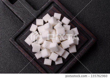 Sweet white sugar cubes as a source of glucose. White sugar cubes as a food background Sweet white sugar cubes as a source of glucose. White sugar cubes as a food background 135762960