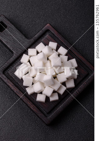 Sweet white sugar cubes as a source of glucose. White sugar cubes as a food background 135762961