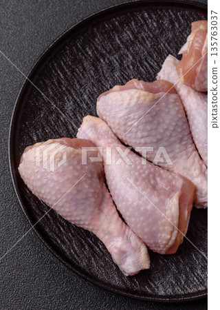 Chicken meat, raw drumsticks on the bone for grilling with salt and spices. Raw chicken drumsticks Chicken meat, raw drumsticks on the bone for grilling with salt and spices. Raw chicken drumsticks 135763037
