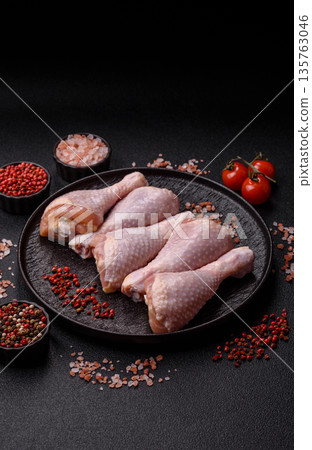 Chicken meat, raw drumsticks on the bone for grilling with salt and spices. Raw chicken drumsticks Chicken meat, raw drumsticks on the bone for grilling with salt and spices. Raw chicken drumsticks 135763046