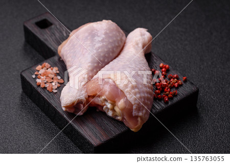 Chicken meat, raw drumsticks on the bone for grilling with salt and spices. Raw chicken drumsticks 135763055