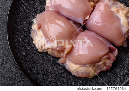 Chicken meat, raw boneless thigh fillets for grilling with salt. Raw chicken thigh fillets Chicken meat, raw boneless thigh fillets for grilling with salt. Raw chicken thigh fillets 135763084