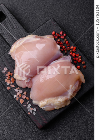 Chicken meat, raw boneless thigh fillets for grilling with salt. Raw chicken thigh fillets 135763104