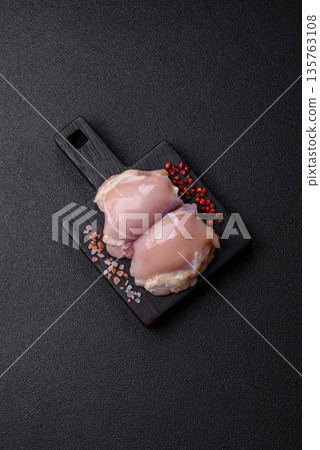 Chicken meat, raw boneless thigh fillets for grilling with salt. Raw chicken thigh fillets 135763108