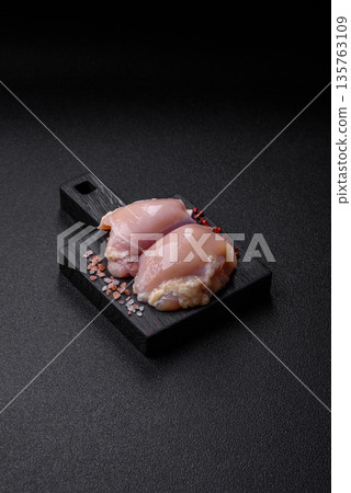 Chicken meat, raw boneless thigh fillets for grilling with salt. Raw chicken thigh fillets 135763109