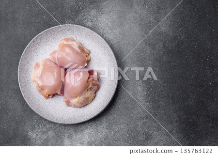 Chicken meat, raw boneless thigh fillets for grilling with salt. Raw chicken thigh fillets 135763122