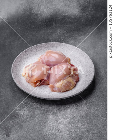 Chicken meat, raw boneless thigh fillets for grilling with salt. Raw chicken thigh fillets Chicken meat, raw boneless thigh fillets for grilling with salt. Raw chicken thigh fillets 135763124