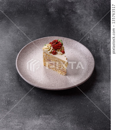 A slice of sweet layered cake with white cream for a birthday or holiday. A slice of cake A slice of sweet layered cake with white cream for a birthday or holiday. A slice of cake 135763517