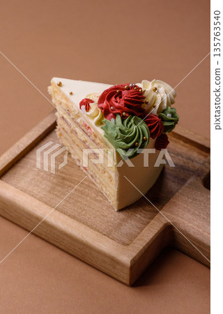 A slice of sweet layered cake with white cream for a birthday or holiday. A slice of cake 135763540