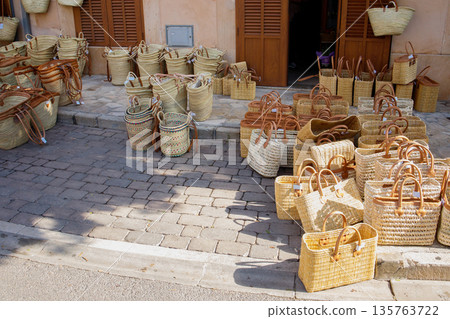 Many different straw bags sold on the street market in Santanyi town on Mallorca, Spain Many different straw bags sold on the street market in Santanyi town on Mallorca, Spain 135763722