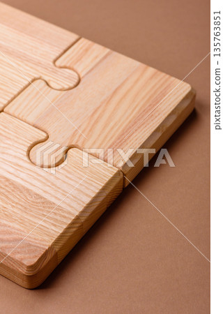 A wooden empty puzzle piece for a sign or business concept. A wooden empty puzzle 135763851