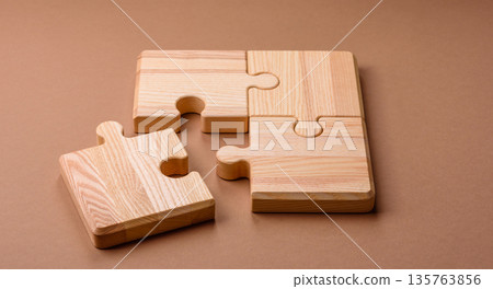 A wooden empty puzzle piece for a sign or business concept. A wooden empty puzzle 135763856