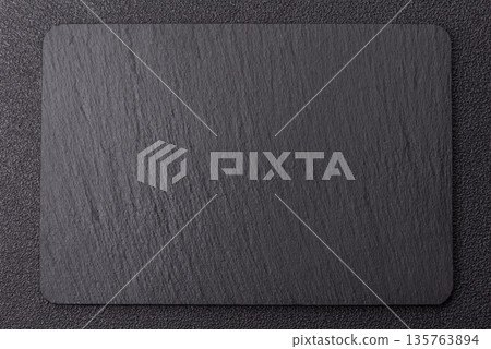 A black slate stone board or plate, an empty kitchen utensil. A black slate board A black slate stone board or plate, an empty kitchen utensil. A black slate board 135763894