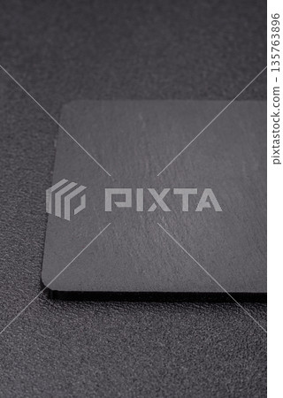 A black slate stone board or plate, an empty kitchen utensil. A black slate board 135763896