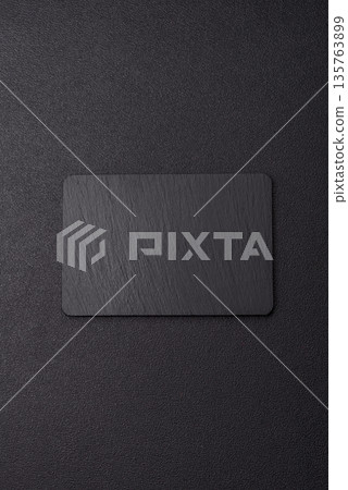 A black slate stone board or plate, an empty kitchen utensil. A black slate board A black slate stone board or plate, an empty kitchen utensil. A black slate board 135763899