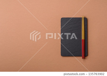 A black slate stone board or plate, an empty kitchen utensil. A black slate board A black slate stone board or plate, an empty kitchen utensil. A black slate board 135763902