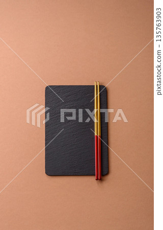 A black slate stone board or plate, an empty kitchen utensil. A black slate board A black slate stone board or plate, an empty kitchen utensil. A black slate board 135763903