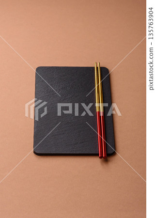 A black slate stone board or plate, an empty kitchen utensil. A black slate board 135763904