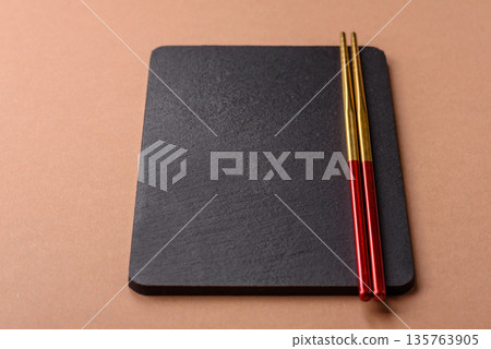 A black slate stone board or plate, an empty kitchen utensil. A black slate board A black slate stone board or plate, an empty kitchen utensil. A black slate board 135763905