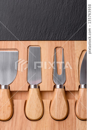A set of cheese knives with a wooden cutting board, slicing tools. Cheese knives 135763938