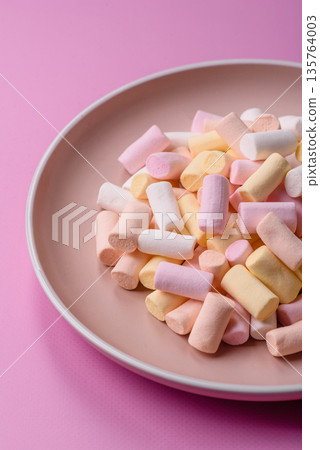 Mini marshmallows in white, pink, and pastel colors. Marshmallows as a food background 135764003