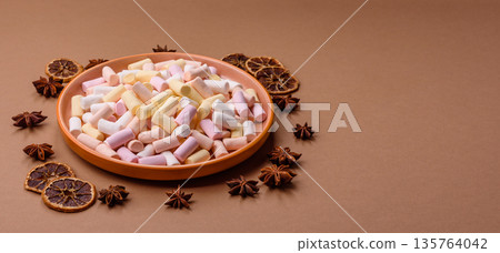 Mini marshmallows in white, pink, and pastel colors. Marshmallows as a food background Mini marshmallows in white, pink, and pastel colors. Marshmallows as a food background 135764042