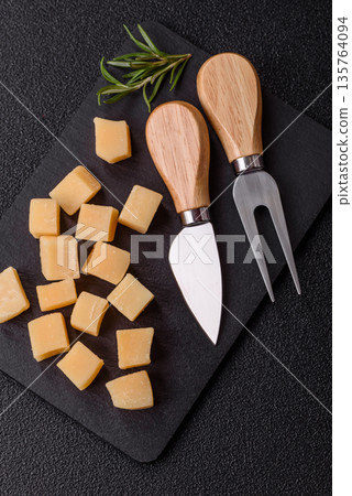 Cubed cheddar, gouda, or parmesan cheese on a cutting board. Cubed cheese Cubed cheddar, gouda, or parmesan cheese on a cutting board. Cubed cheese 135764094