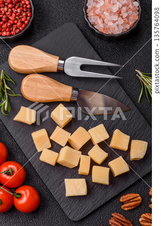 Cubed cheddar, gouda, or parmesan cheese on a cutting board. Cubed cheese Cubed cheddar, gouda, or parmesan cheese on a cutting board. Cubed cheese 135764098