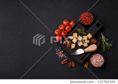 Cubed cheddar, gouda, or parmesan cheese on a cutting board. Cubed cheese 135764104