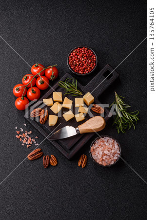 Cubed cheddar, gouda, or parmesan cheese on a cutting board. Cubed cheese 135764105