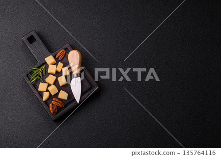 Cubed cheddar, gouda, or parmesan cheese on a cutting board. Cubed cheese Cubed cheddar, gouda, or parmesan cheese on a cutting board. Cubed cheese 135764116